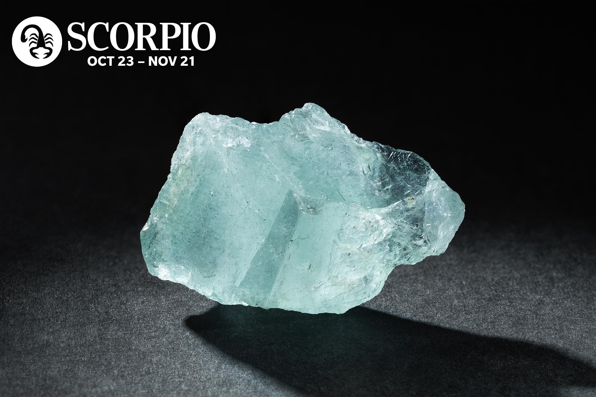 Aquamarine stone with the scorpio symbol and dates in the upper left corner