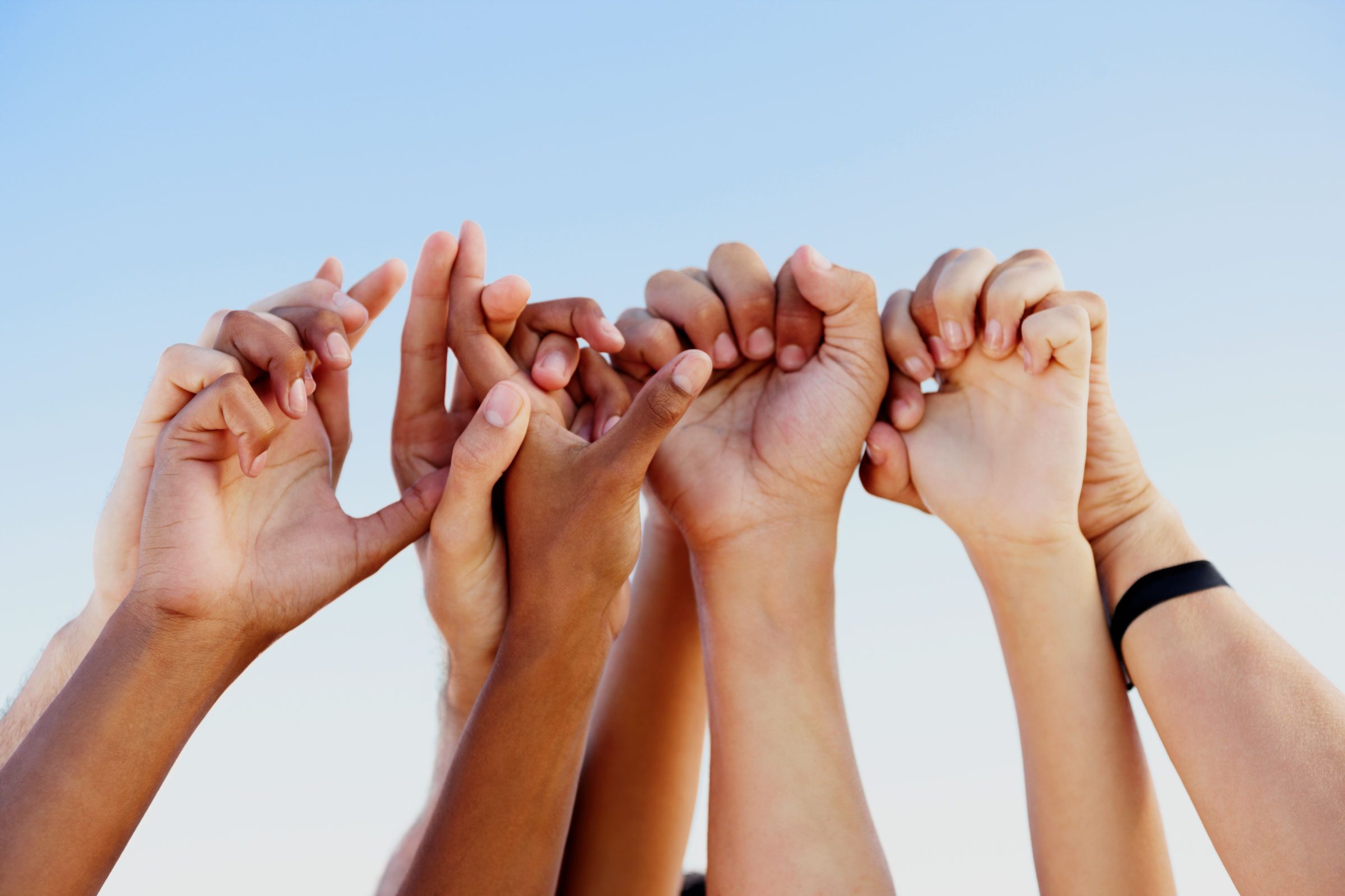 hands reaching towards the sky and linking fingers