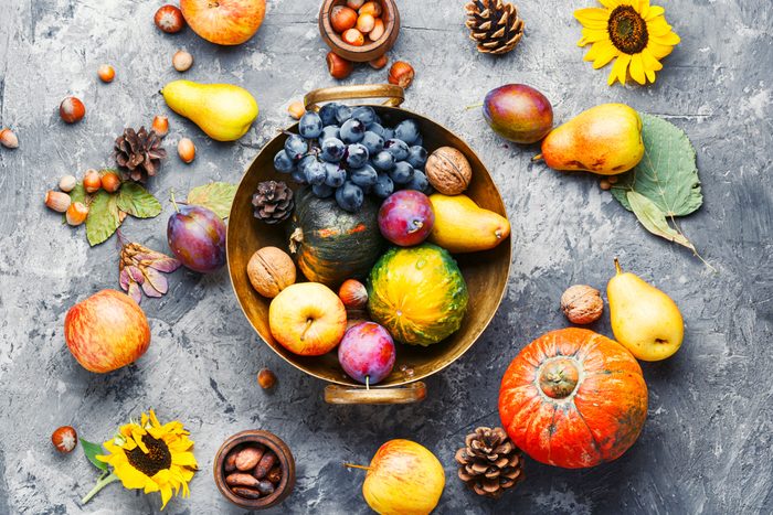 Fall Food still life with grapes, pumpkins, apples, pears, plums, sunflower, nuts and pinecones