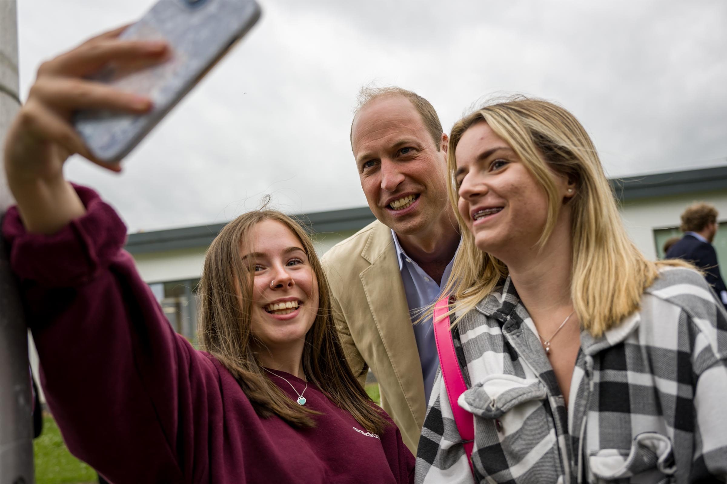 rince William, Prince of Wales poses for a selfie as he visits Tillydrone Community Campus to spotlight how co-located and joined up community support services can improve early intervention and prevent homelessness, as part of his tour of the UK to launch a project aimed at ending homelessness on June 27, 2023 in Aberdeen, United Kingdom.