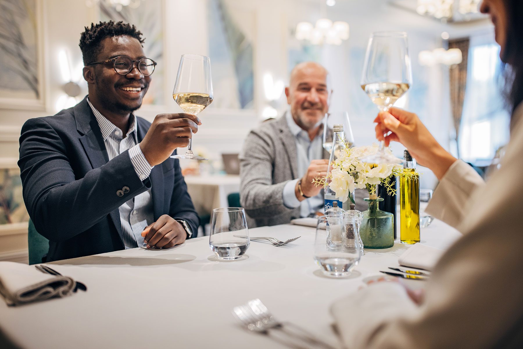 People raising their glasses at table in a restaurant