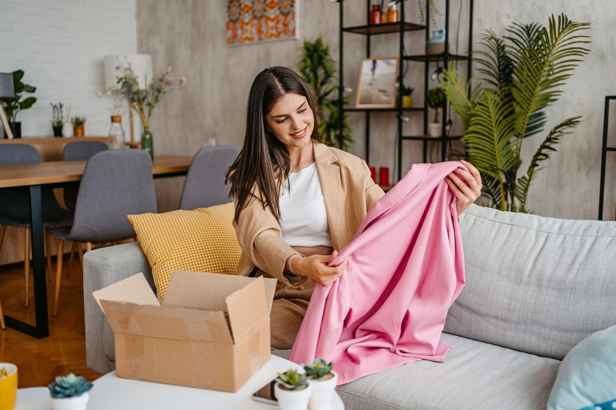 Beautiful Woman Unpacking Parcel Ordered Online At Home