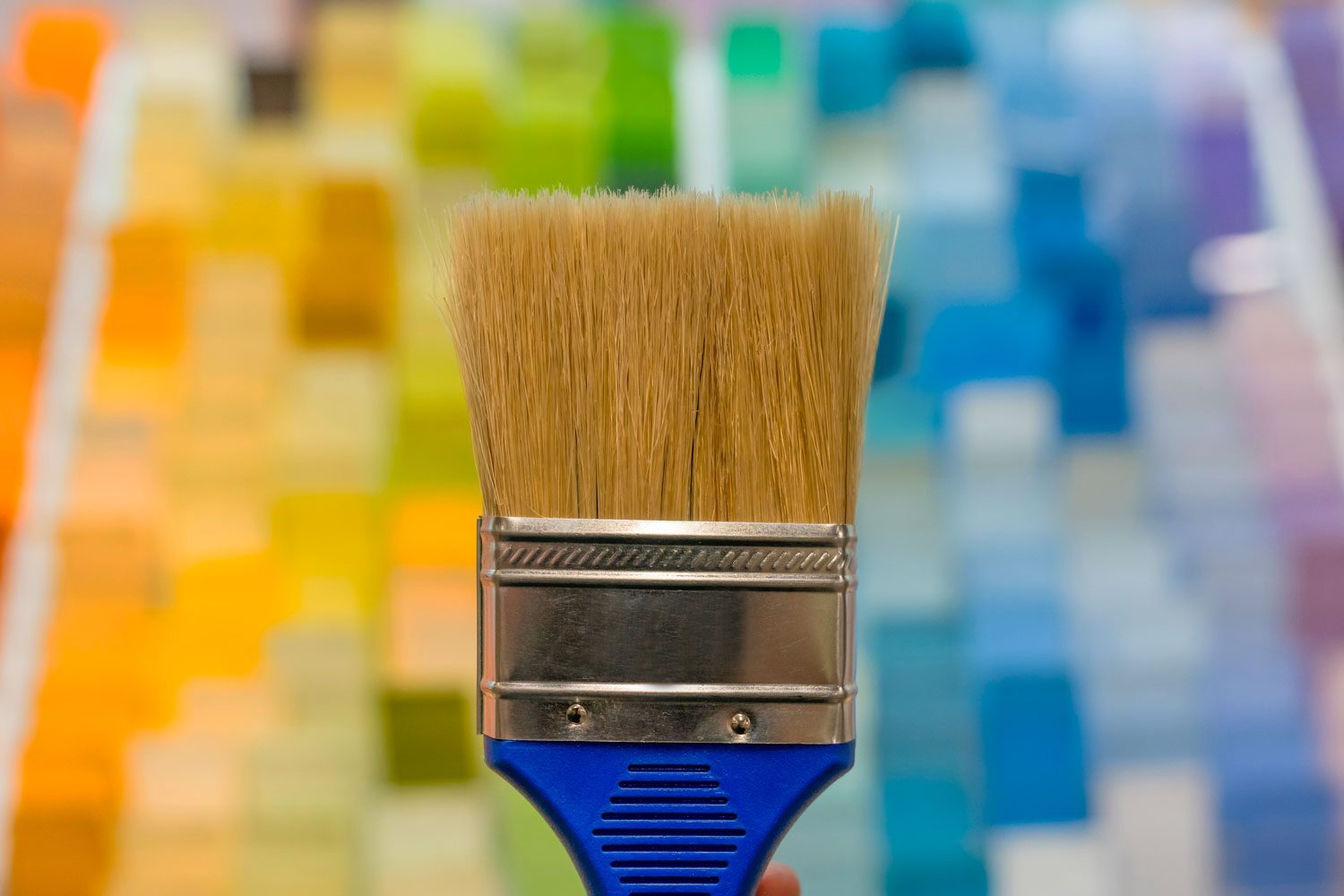 Paintbrush in from of a background of paint chips in a home improvement store