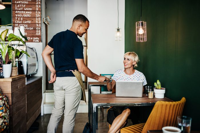 Woman Receiving Coffee She Ordered At Cafe