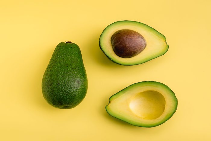 Avocado flat lay on yellow background. Simple and minimal concept. Organic healthy food. Top view