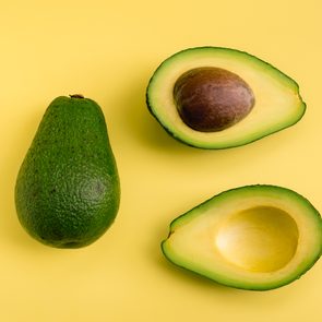 Avocado flat lay on yellow background. Simple and minimal concept. Organic healthy food. Top view