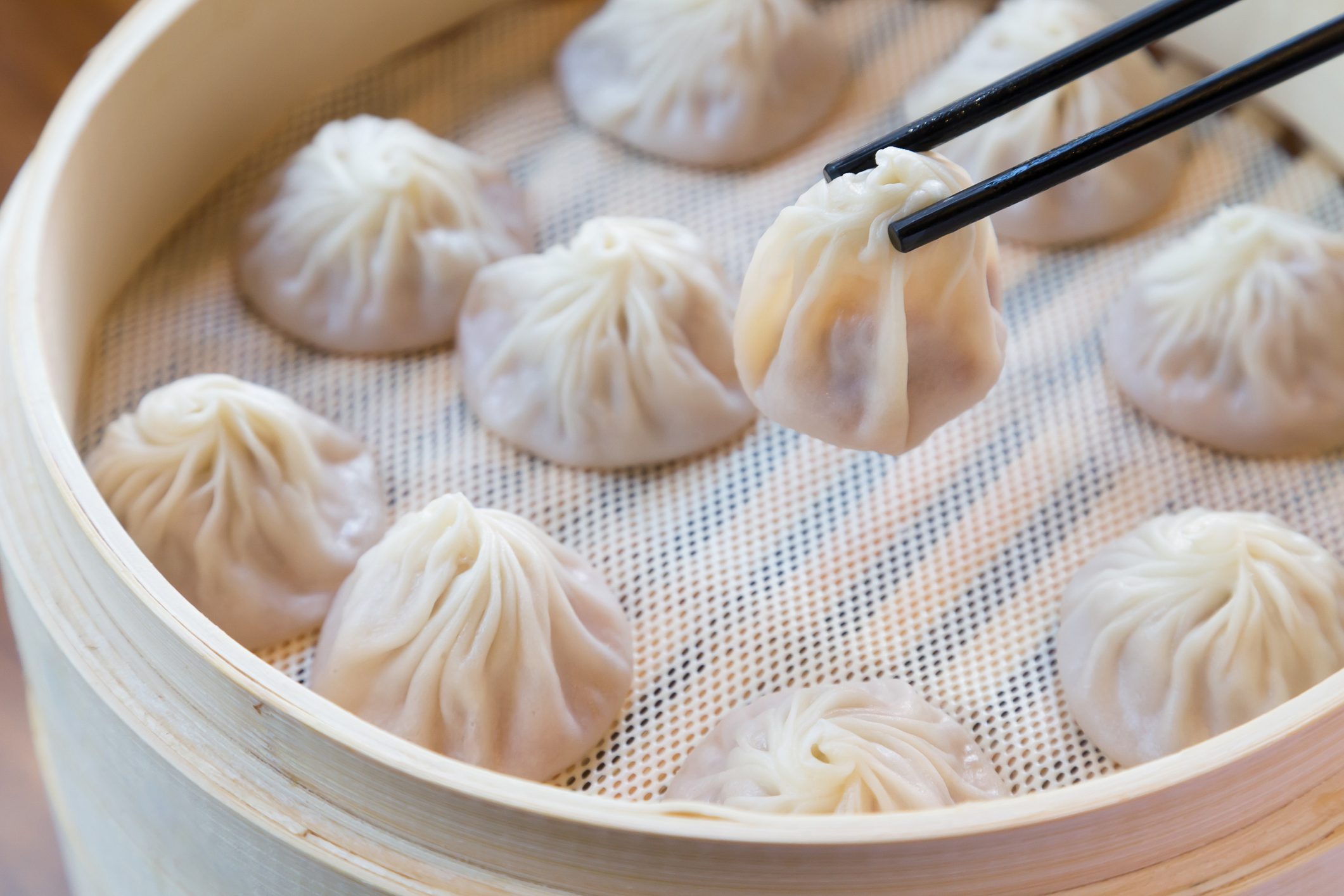 Closeup of Xiao Long Bao with chopsticks, Streamed Pork Dumplings Chinese food.