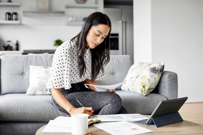 Woman working while sitting on couch