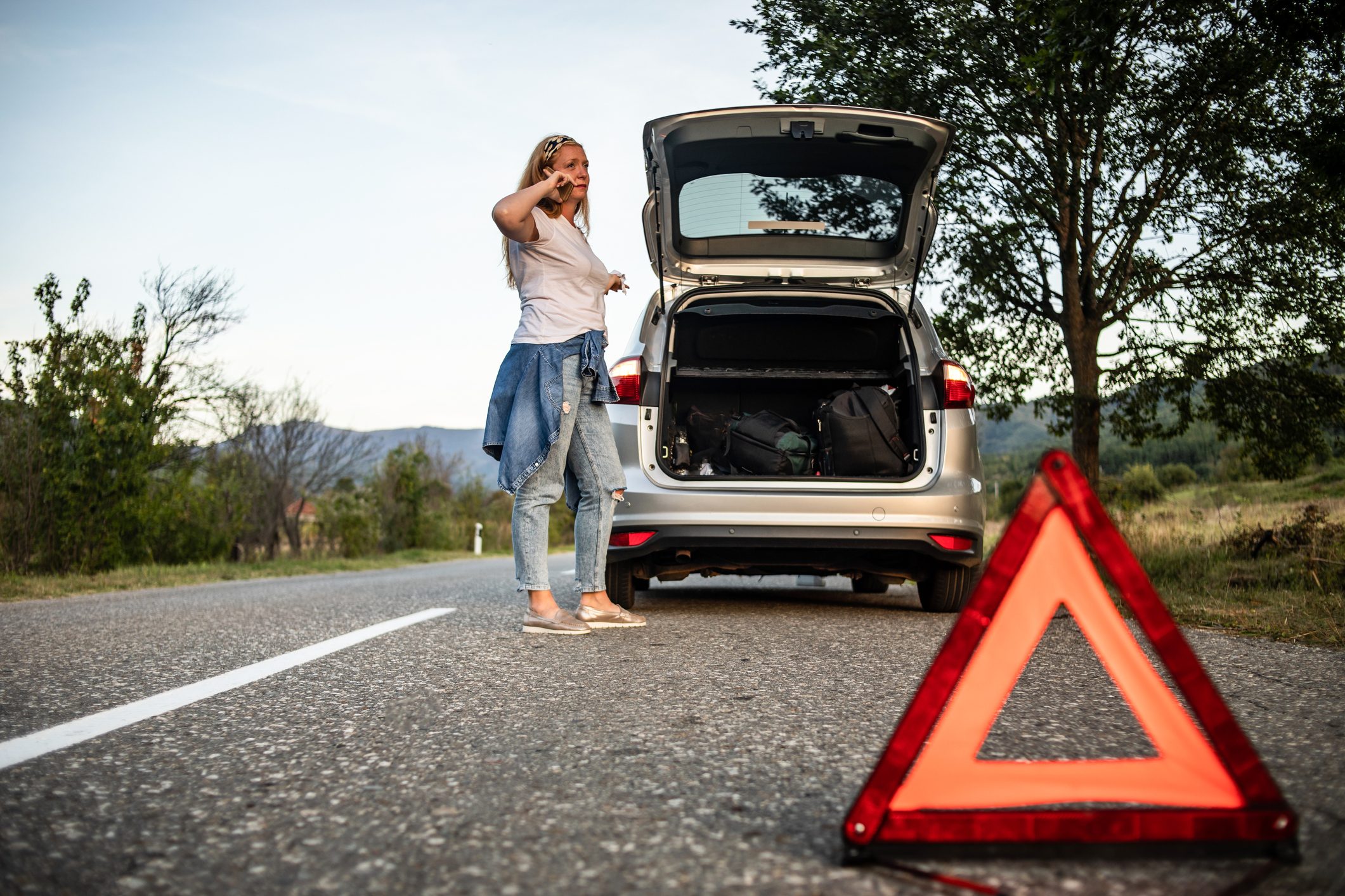 The woman calls the roadside assistance service.