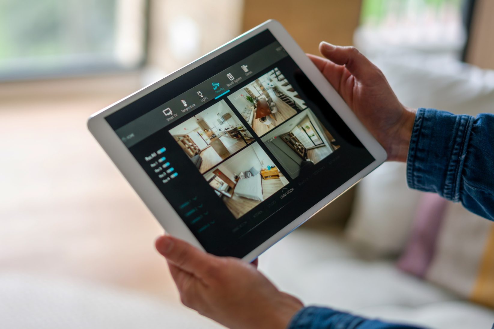 Woman monitoring her house with a home security system