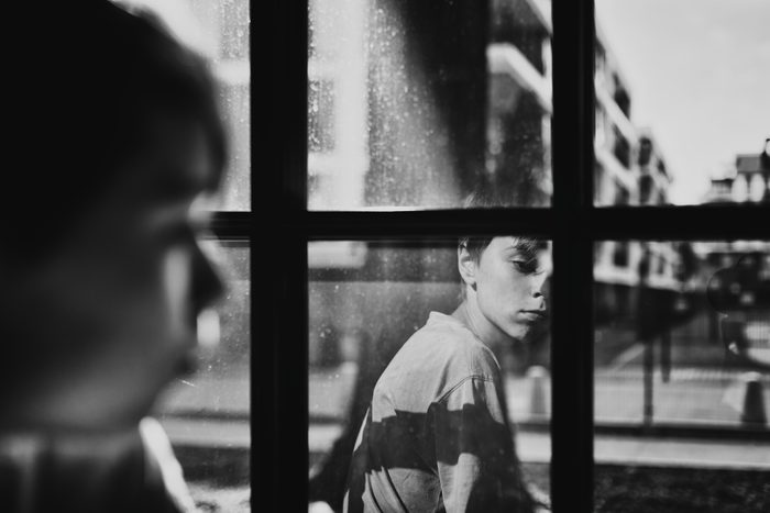 Sad boy looking through window