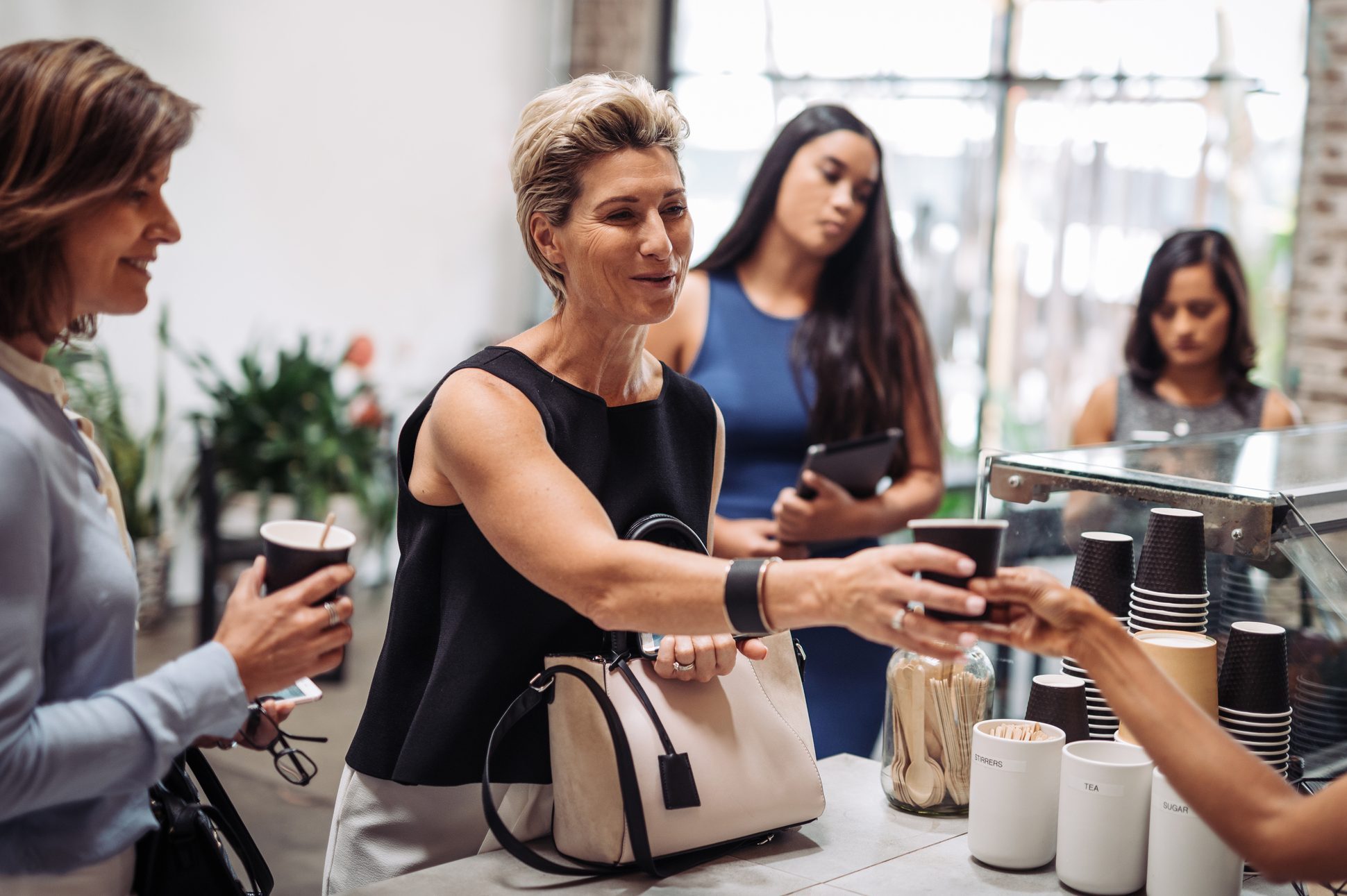 Healthy businesswoman ordering organic coffee in vegan snack bar