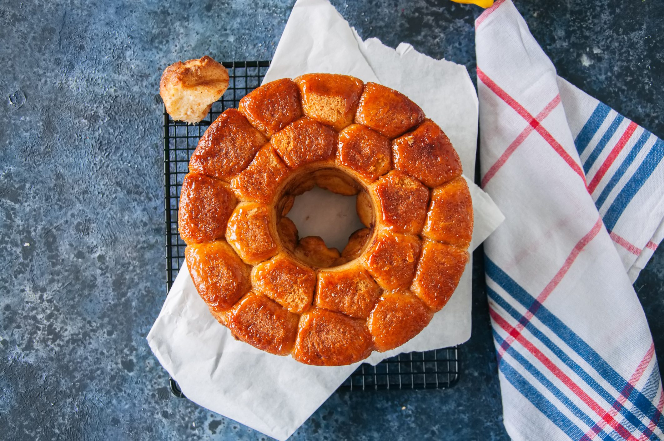 Homemade caramel monkey bread with brown sugar and lemon zest on a blue stone background