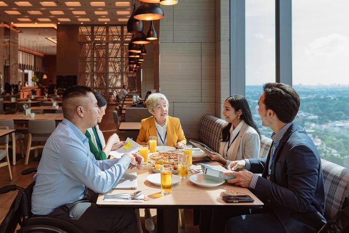 Businesswoman and her diverse team bonding over a meal