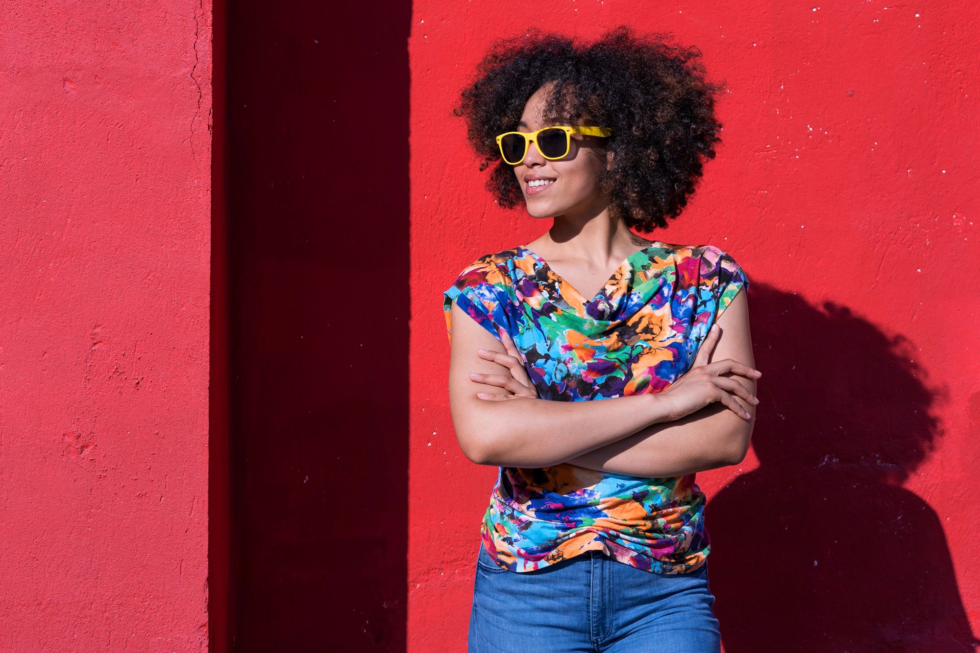 Smiling African American Woman Standing In Front Of A Red Background