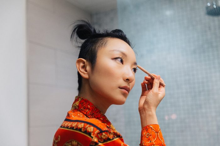 Young woman doing makeup