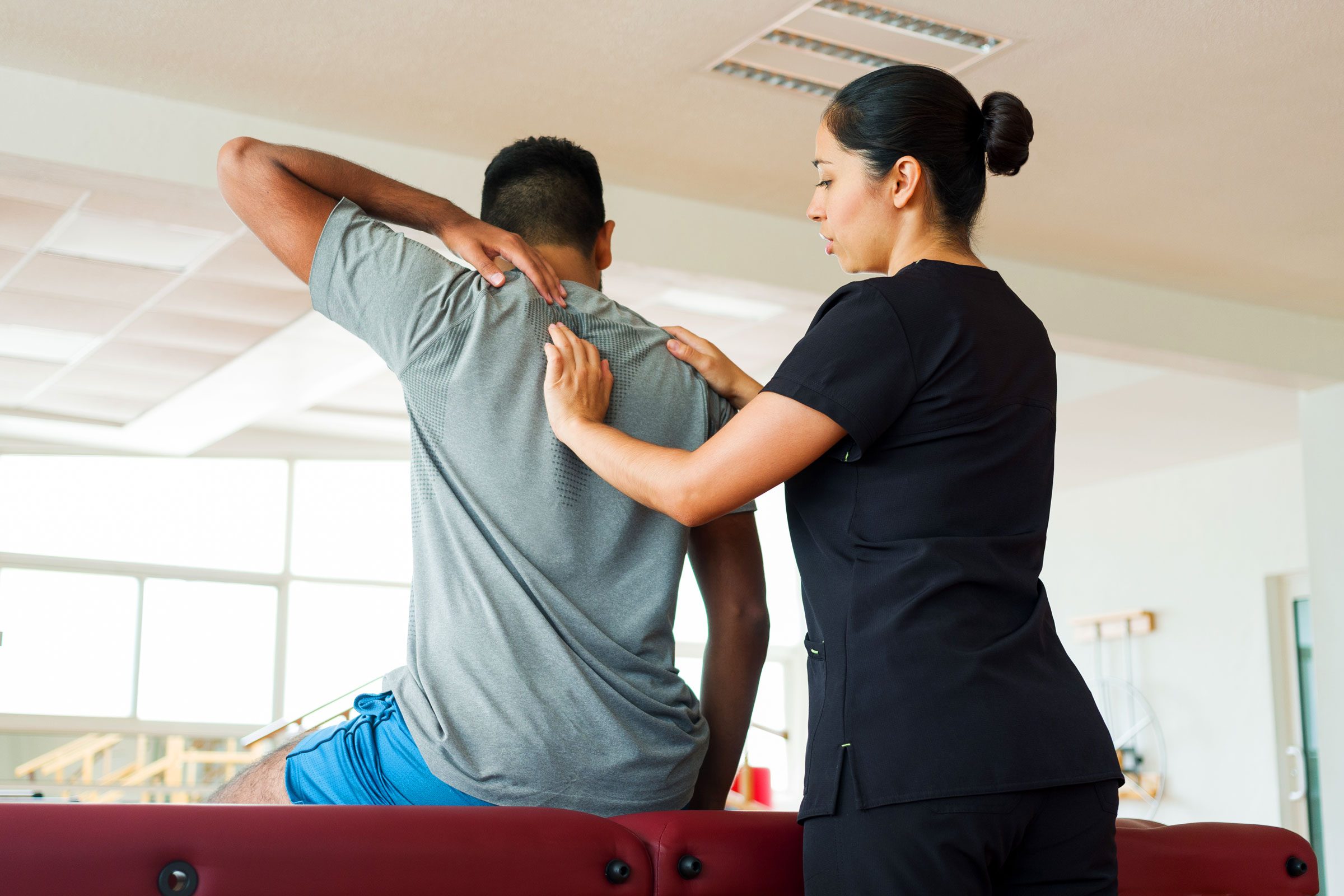 man recieving massage therapy and giving feedback