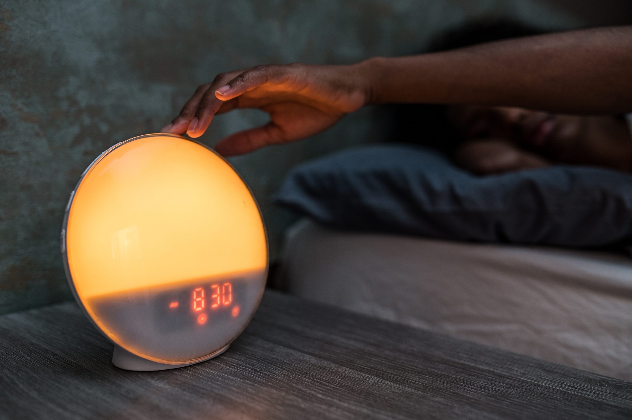 African American woman turning off alarm clock