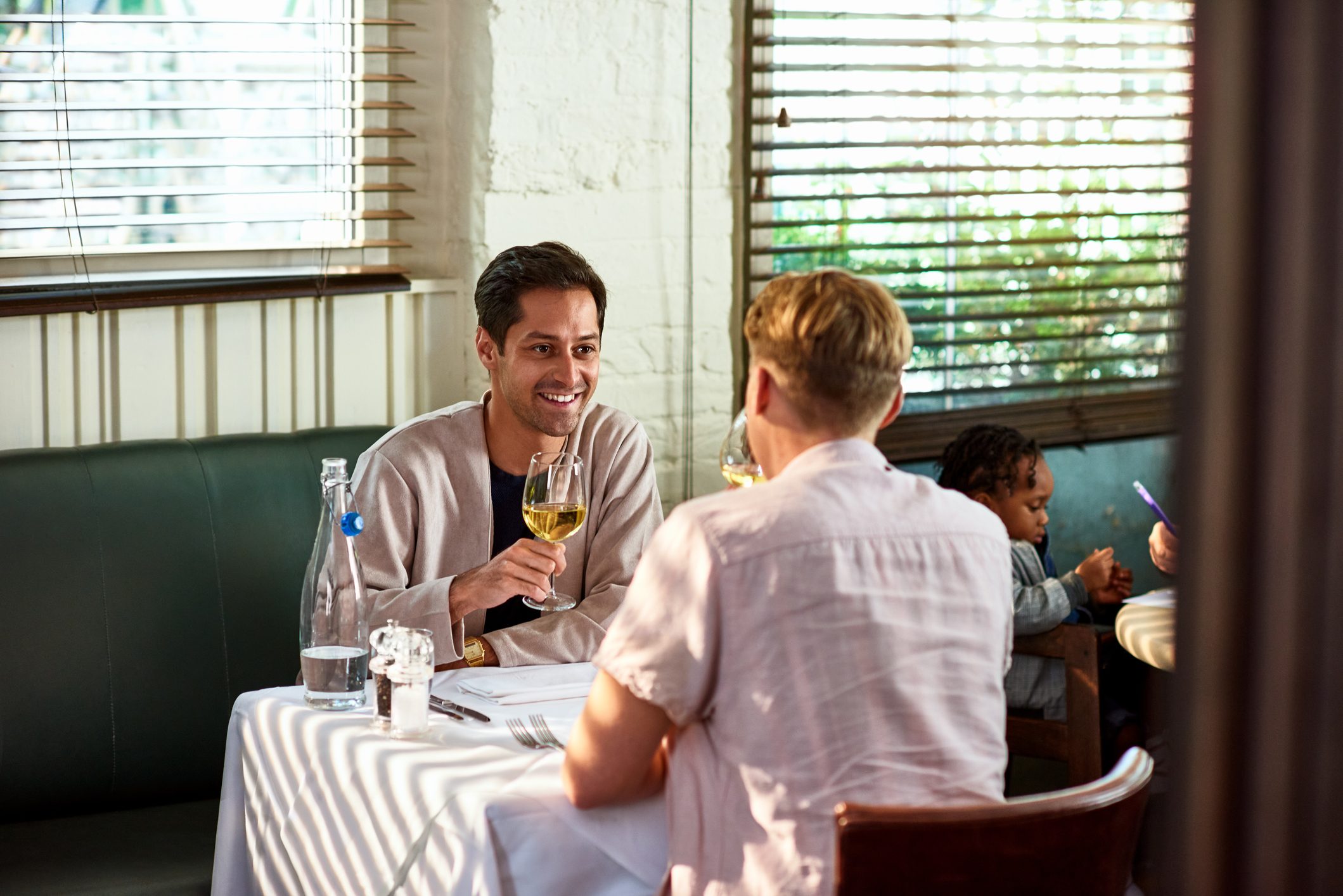 Gay couple drinking wine in restaurant