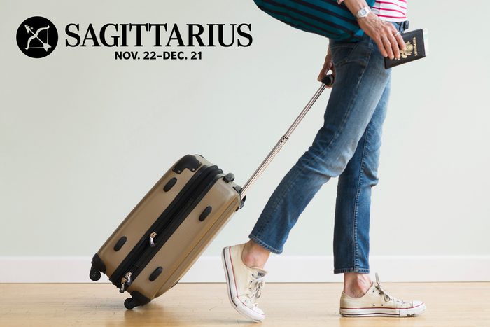 lower half of woman walking with rolling suitcase