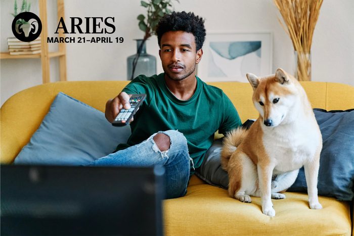 man with dog watching TV