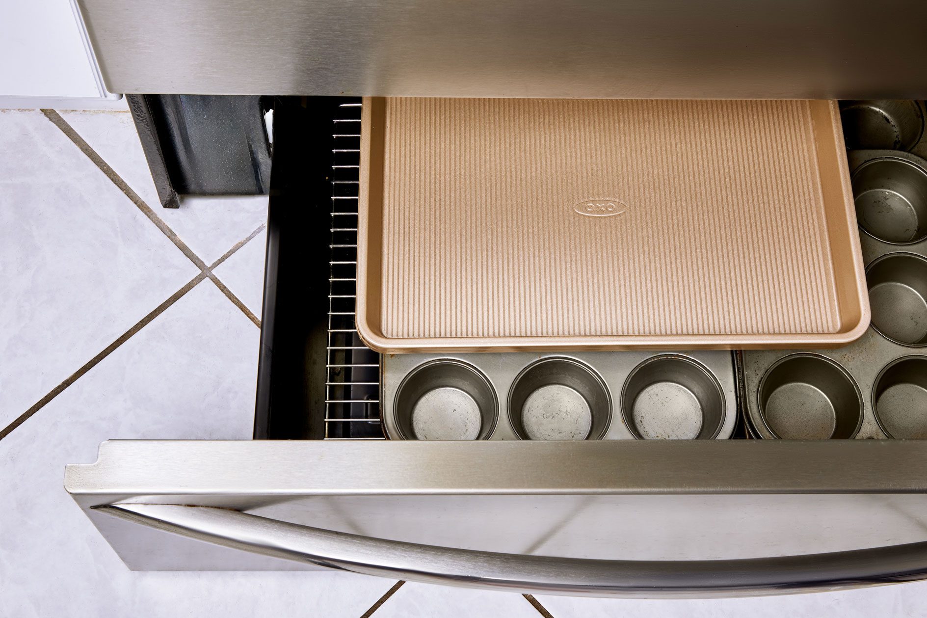 flat pans and baking sheets in open oven drawer