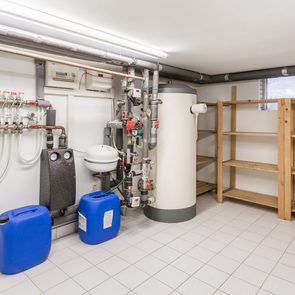 Basement with water heater, pipes and wooden shelves