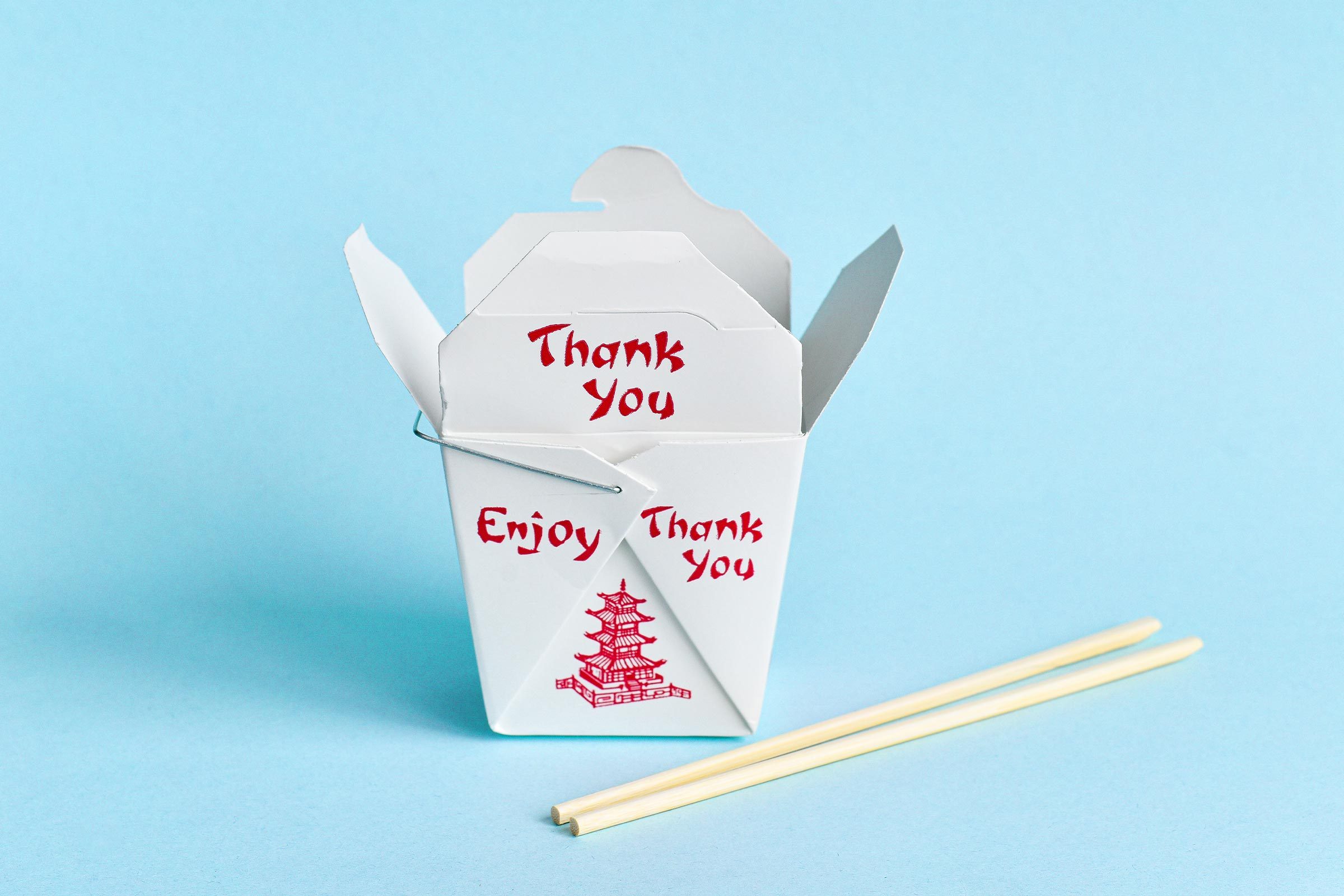 take out container with chopsticks on a blue background