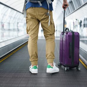 A Traveler walking on moving walkway in the airport