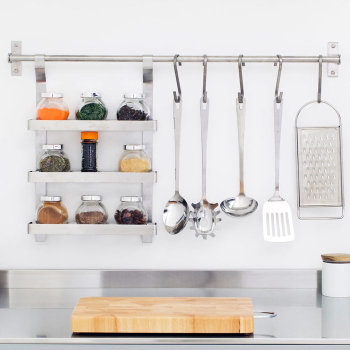 Kitchen Utensils And Spices Hanging On Kitchen Rail Bar