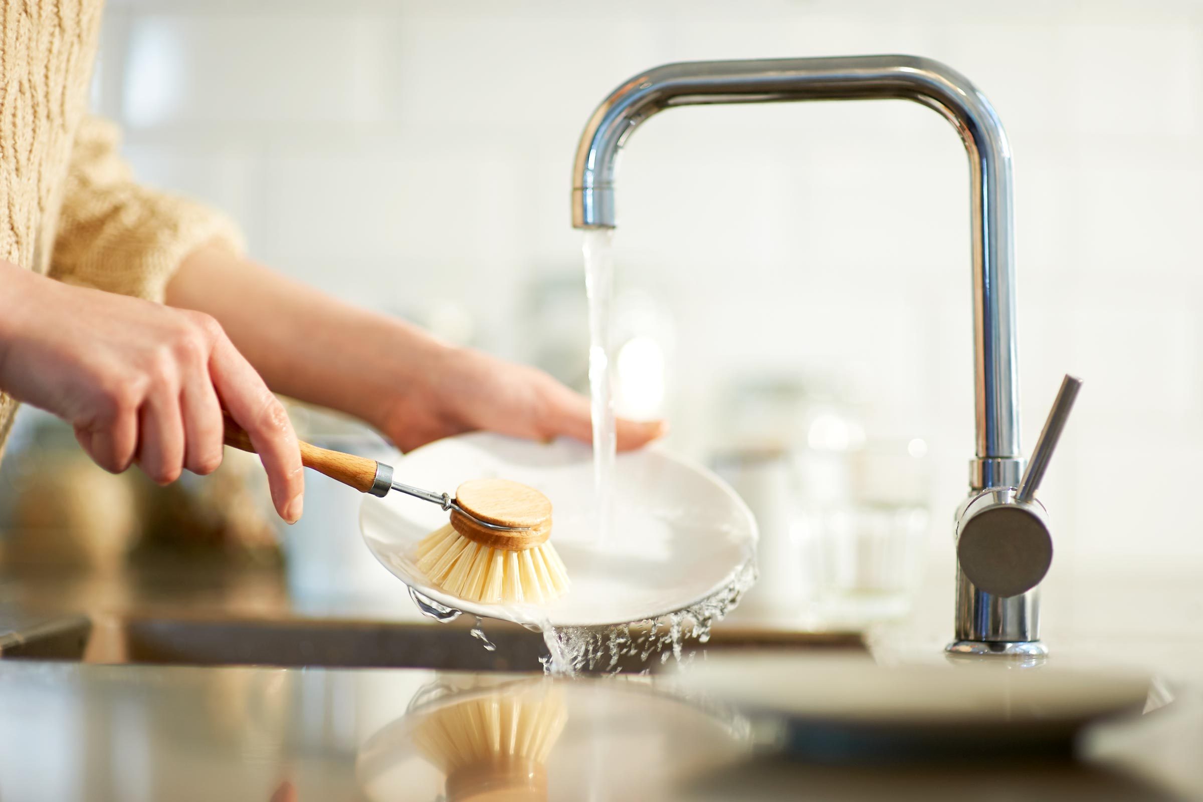 washing dishes with dish brush