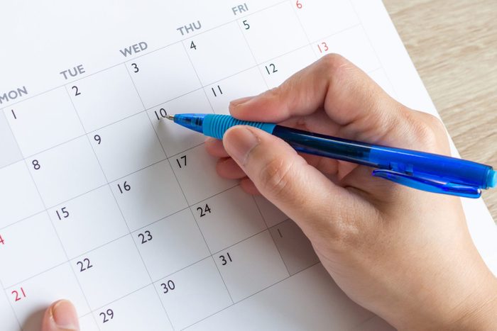 Woman hand with pen writing on calendar date business planning appointment meeting concept