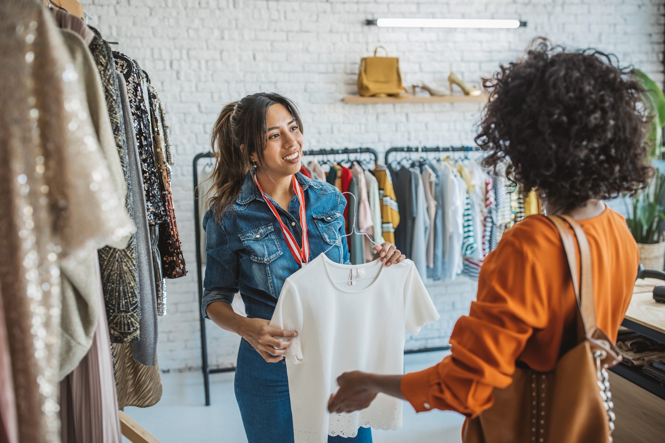 woman asking retail worker if they like their job at a clothing store