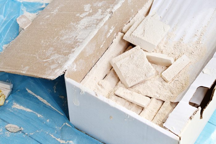 A box with tiles lies on a blue background