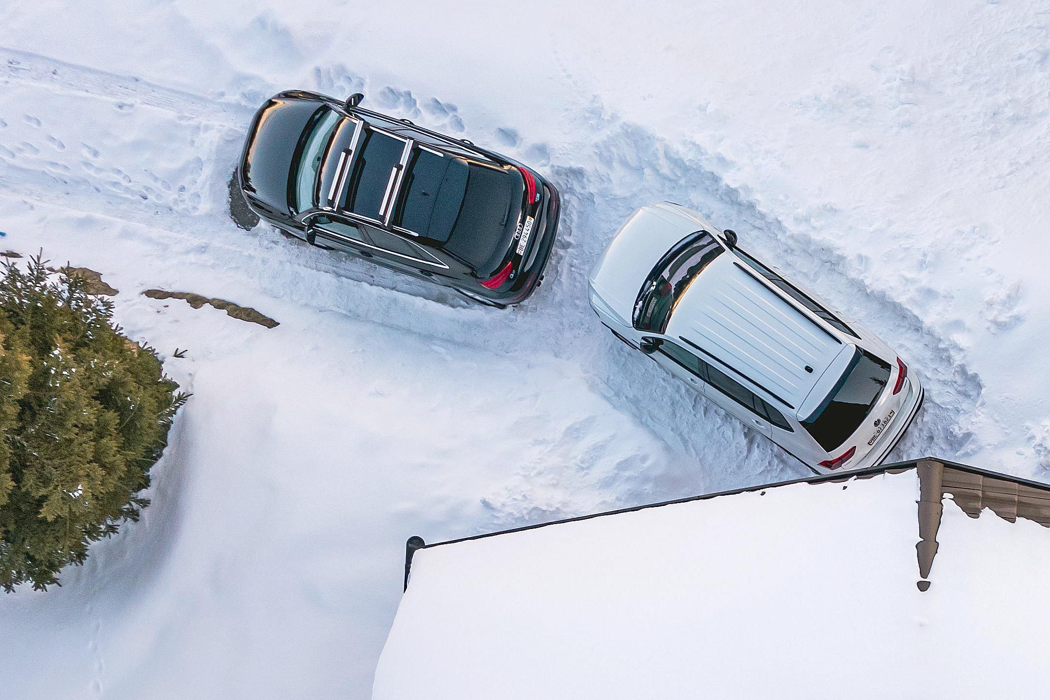 two cars parked in a snowy driveway