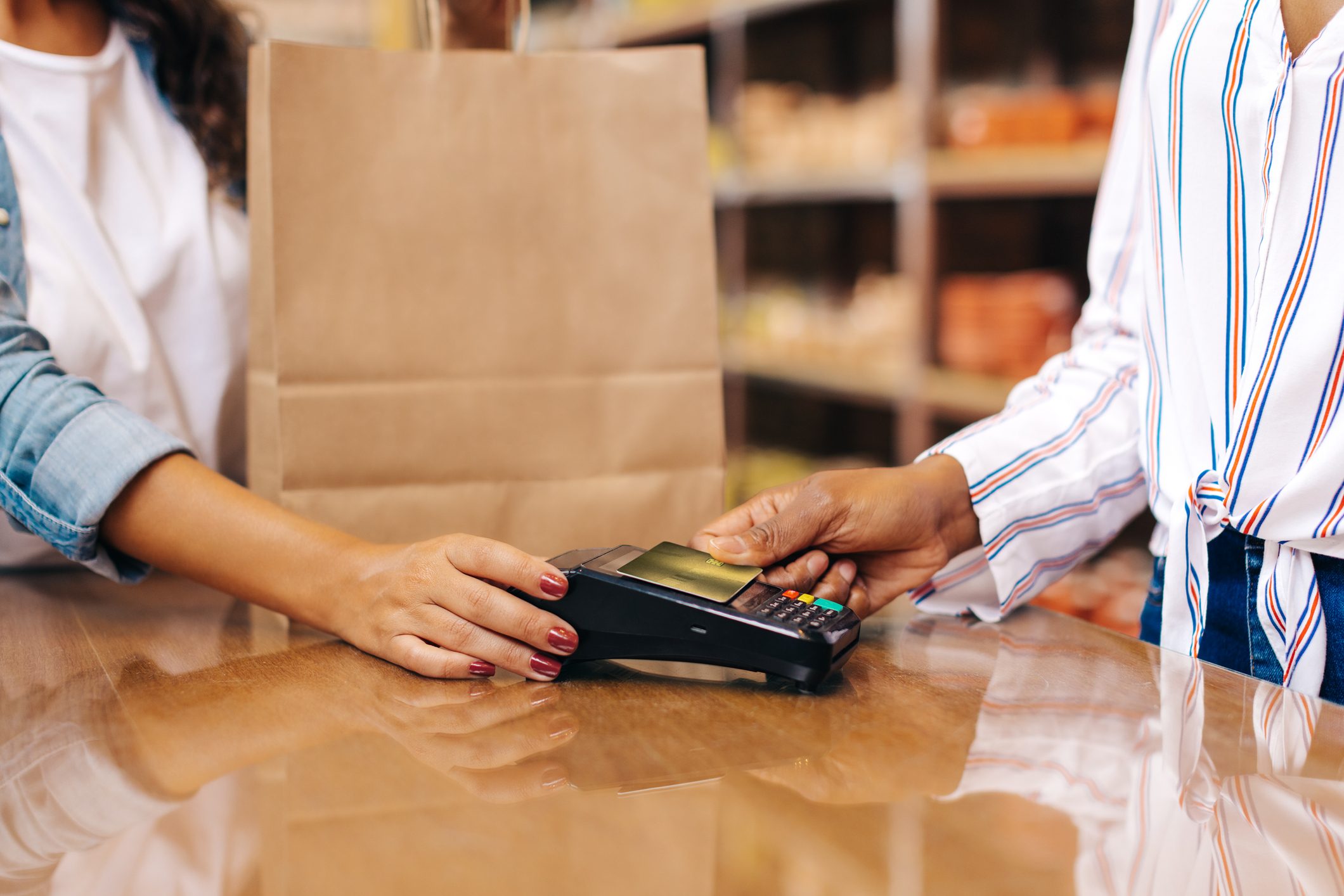 Unrecognizable shop owner receiving a credit card payment in her ceramic store