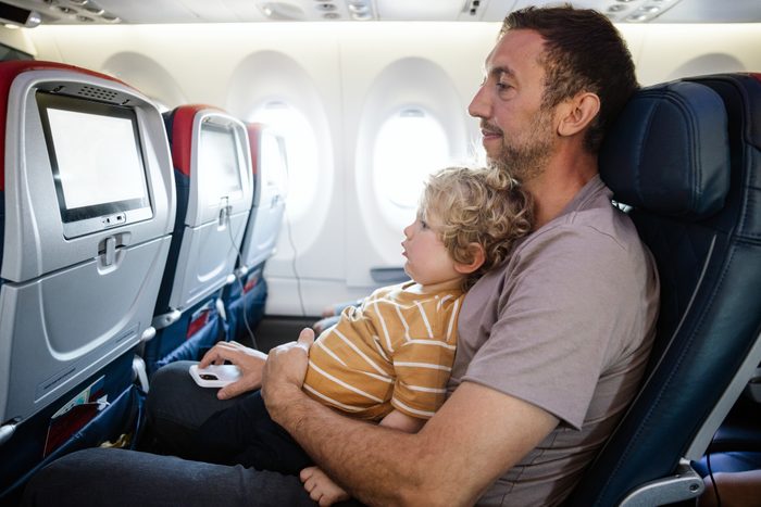 Father Riding Airplane With Toddler Son on Lap