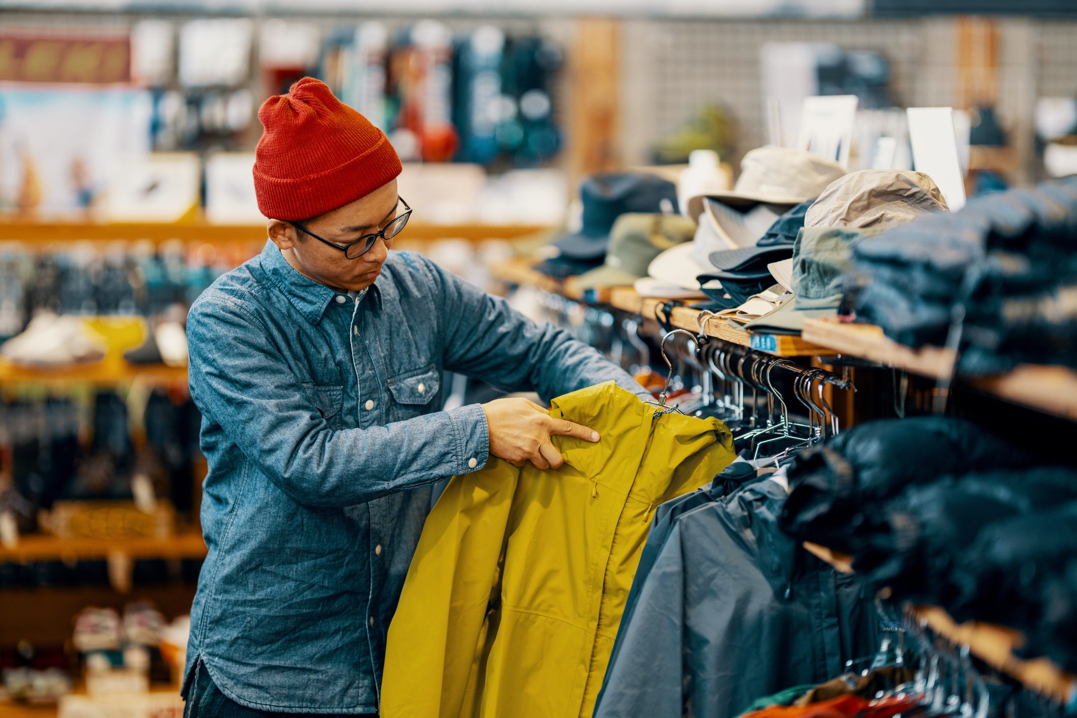 Mid adult retail staff folding items in a clothing store