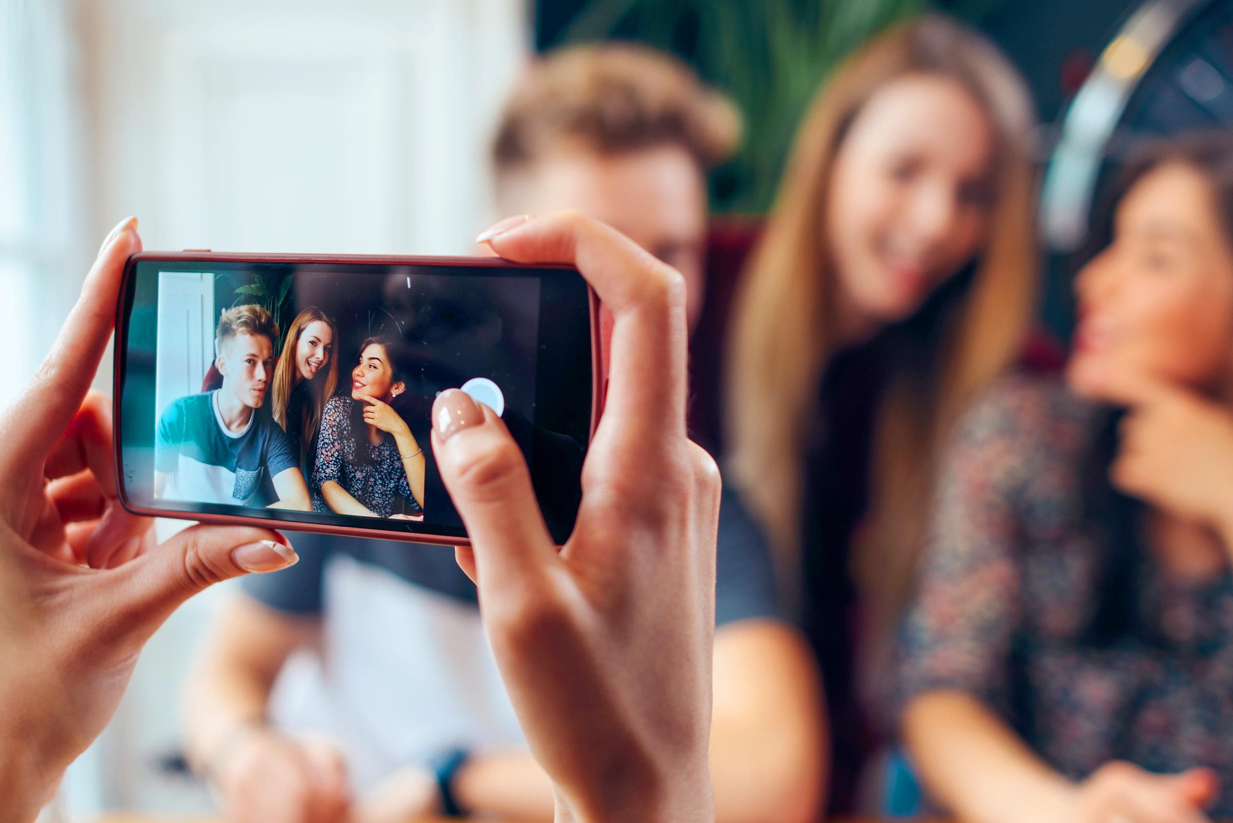 taking picture of three friends on a phone