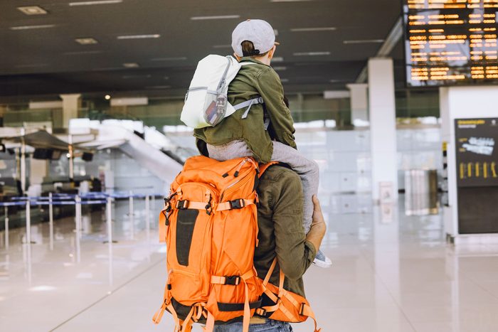 father and son with backpacks at an airport