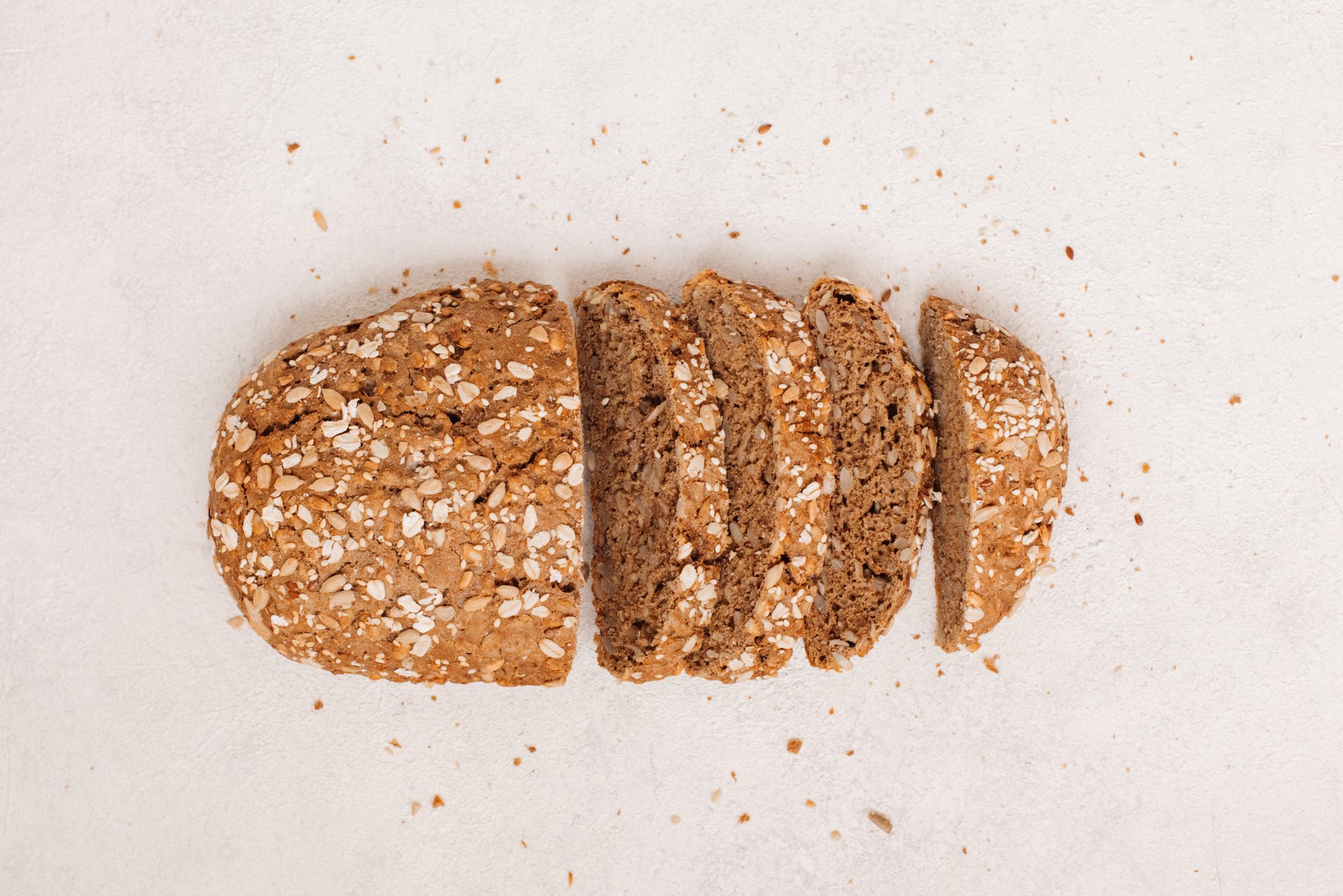 Top view of sliced wholegrain bread on dark ructic wooden background closeup