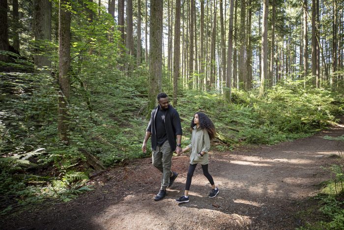 Dad smiling to his daughter on the forest trail