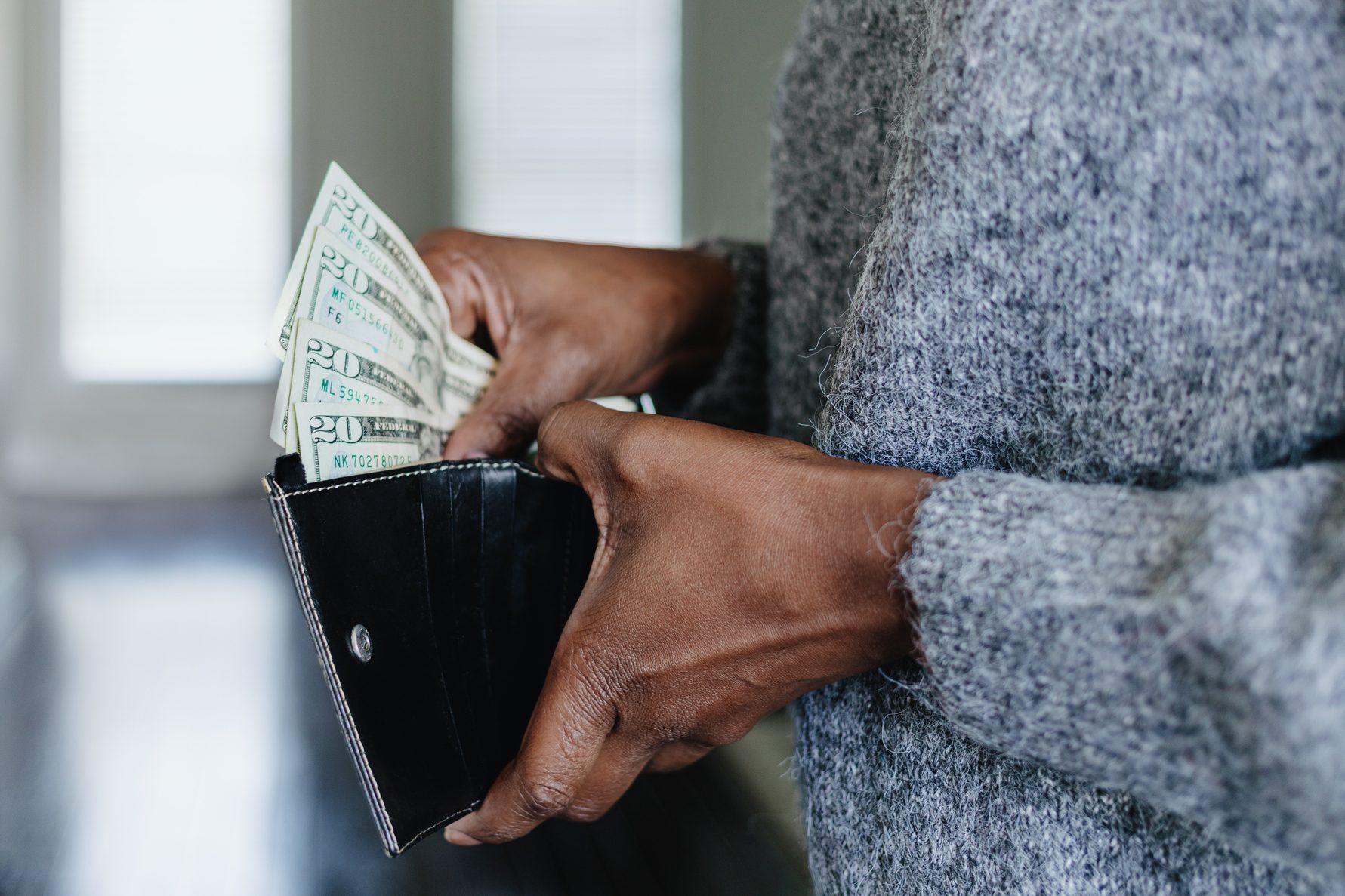 Woman Inserts Cash Into Wallet