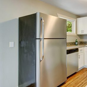 Furnished kitchen room with white cabinets and steel appliances