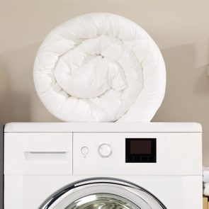 down comforter on top of a washing machine in laundry room