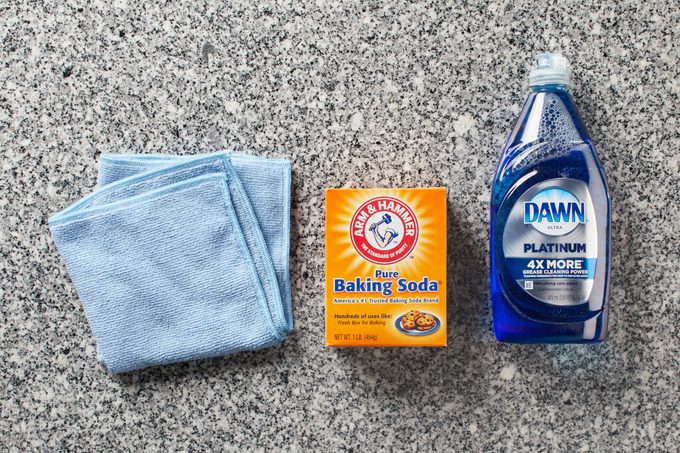microfiber cloth and dish soap and baking soda on a granite countertop