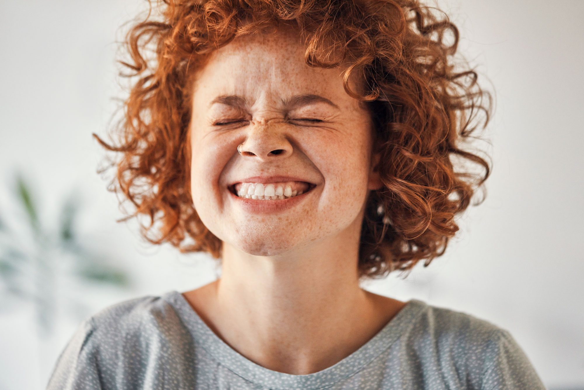 close up of a woman with red hair wincing in pain