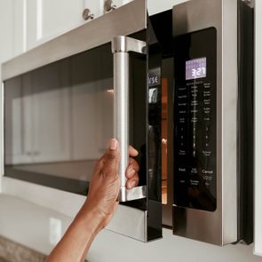 Close-Up of Woman Opening Microwave