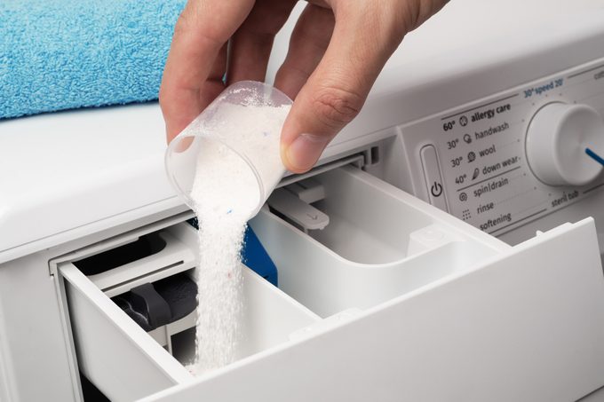 Putting the washing powder in the washing machine. The concept of laundry.