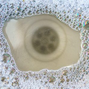 filled and clogged kitchen sink with soapy dirty water